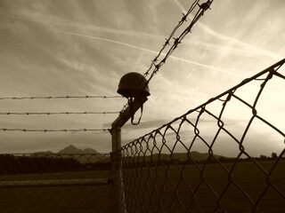 Helm im Stacheldrahtzaun