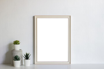 Empty white photo frame with cultus over the light wall.