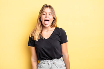 blonde pretty woman with cheerful, carefree, rebellious attitude, joking and sticking tongue out,...