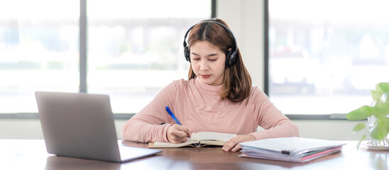Young Woman College Student Wears Headphone Look at Laptop Study Online at Home