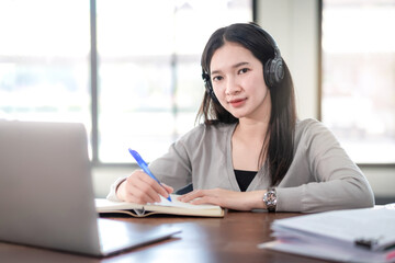 Young Woman College Student Wears Headphone Look at Laptop Study Online at Home