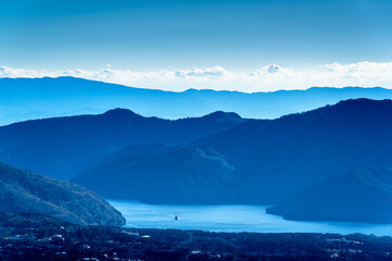 View of dark blue waters of Lake Ashi (elev. 723 m / 2,372 ft) in Hakone mountains as seen from summit of Mt. Kintoki (elev. 1,212 m / 3,976 ft) on clear winter day in Shizuoka Prefecture, Japan.