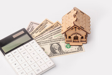 money, dollars, white calculator, toy house concept of buying and maintaining a house, apartment, credit relations, loan
