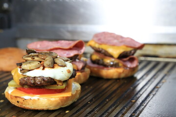 Fresh tasty burger on dark background - Hamburgers cooking on grill