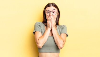 hispanic pretty woman happy and excited, surprised and amazed covering mouth with hands, giggling...