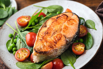 Salad with roasted salmon steak on plate, closeup view
