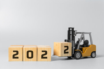 2022 new year background concept. happy new year industrial concept, forklift carrying box to complete 2022 text.