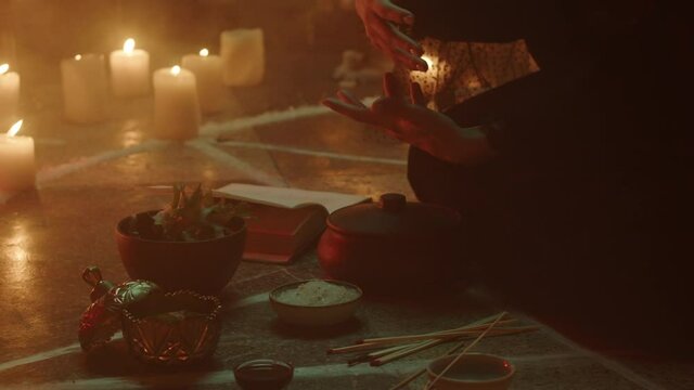 Witch woman sitting in pentagram circle and cooking potion. Evil sorceress making rite and sacrifices at night, using black witchcraft, candles on floor. Halloween tradition, usa holiday. 