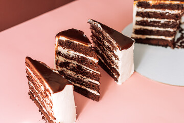 Four pieces of puff chocolate cake on pink background