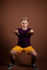 A student doing sports with full-length dumbbells. A man in retro style on a brown background.