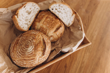 Freshly baked homemade bread on a tray on a wooden table. Home craft. Sourdough bread. View from above