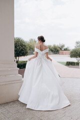 Fototapeta na wymiar beautiful bride in a white dress walking on the street summer wedding youth hairstyle
