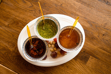 Top view of different delicious sauces on white plate on the table