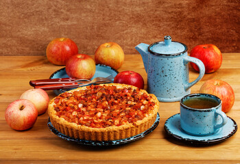 Homemade pie with apples, raisins and cinnamon on wooden table.