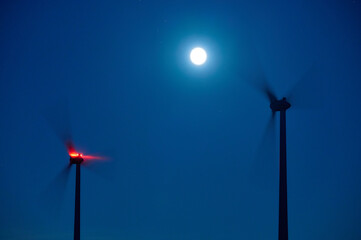 wind turbine at night full moon - Powered by Adobe
