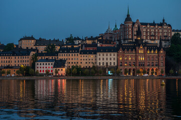 At sunset, houses in Sodermalm are reflected in the water of the Riddarfjorden. Stockholm, Sweden.
