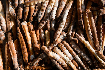Close-up top view of long crispy breadsticks on silver tray.