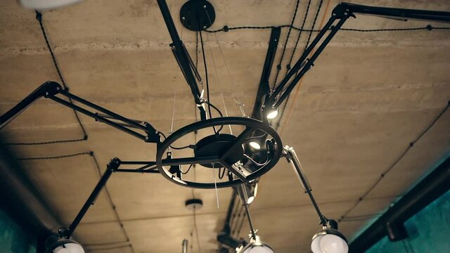 Hair salon interior. Interior of a modern hair salon. Modern original chandelier spider made of metal. The light bulbs are off.