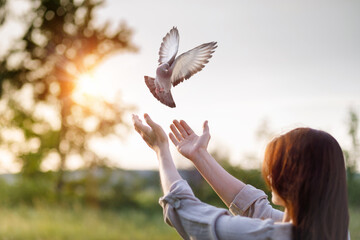 Dove flies into the hands of a woman during prayer as a symbol of hope.