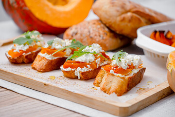 grilled ciabatta bruschetta with baked pumpkin, feta arugula and spices. healthy fall baked pumpkin snack