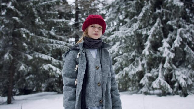Front view of of preteen girl outdoors in winter nature, copy space.