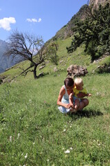 mother and little son explore the world and have fun in the summer mountains	