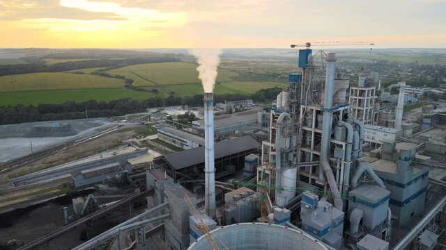 Aerial view of cement factory tower with high concrete plant structure at industrial production area. Manufacturing and global industry concept.