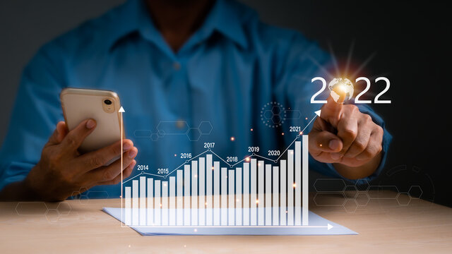 Businessmen point to the top of the stock graph. The concept is business analytics and financial, Plans to increase business growth and indicators of positive growth in 2022