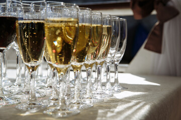 in several rows glasses with drinks of white and red wine