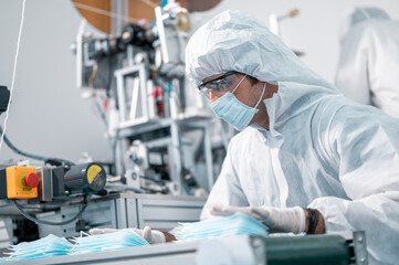 Scientists wearing uniform protection. Check the manufacturing process of face masks. In a laboratory at industry plants. The concept for security and protection coronavirus covid-19.
