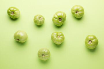 Green tomatoes for conservation on a green background. Unripe tomatoes for harvesting.
