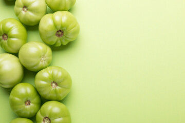Green tomatoes for conservation on a green background. Unripe tomatoes for harvesting.