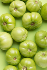 Green tomatoes for conservation on a green background. Unripe tomatoes for harvesting.