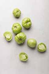 Green tomatoes for conservation on a gray background. Unripe tomatoes for harvesting. Cutaway tomato.