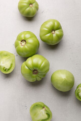 Green tomatoes for conservation on a gray background. Unripe tomatoes for harvesting. Cutaway tomato.