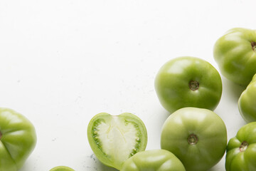 Green tomatoes for conservation on a gray background. Unripe tomatoes for harvesting. Cutaway tomato.