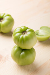 Green tomatoes for conservation on a wooden background. Unripe tomatoes for harvesting.