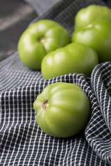 Green tomatoes for conservation on a dark marble background. Unripe tomatoes for harvesting. Cutaway tomatoes.