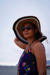 Colombian woman, poses with sunglasses and hat