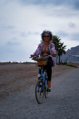 Colombian woman riding a bike on the beach