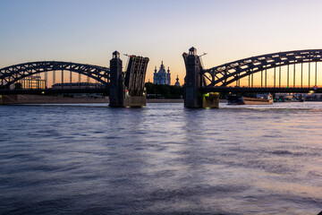 The bridging of Bolsheokhtinsky bridge on the Neva river overlooking the Smolny Cathedral during the white nights. Saint Petersburg, Russia