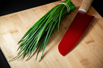 knife, chives and wood cutting board