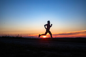 active man silhouette running at sunset