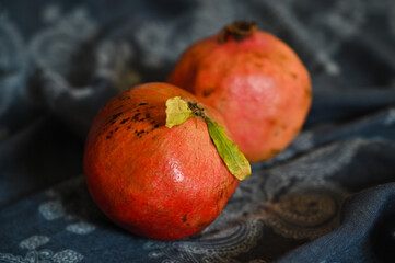 Fototapeta na wymiar A whole pomegranate is lying on the wooden embankment tablecloths