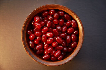 Natural healthy dogwood berry in the clay bowl. Autumn healthy food for vitamin compote or tea. Copy space