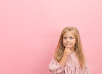 Little pencive girl in dress on pink background with copy-space.