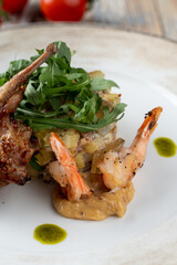 Roasted quail with salad and king prawns as an exquisite dining in a restaurant
