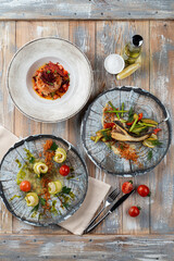 Assorted mediterranean meals of a fancy restaurant, served on vintage veranda table, above shot