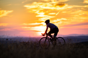 cyclist silhouette at sunset sports and fitness concept