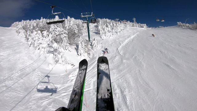 Ski winter vacation concept video. Ski lift and gondola. First person view POV with skis. Skiing on snow slopes in the mountains, People having fun on a snowy day - Winter sport outdoor activity